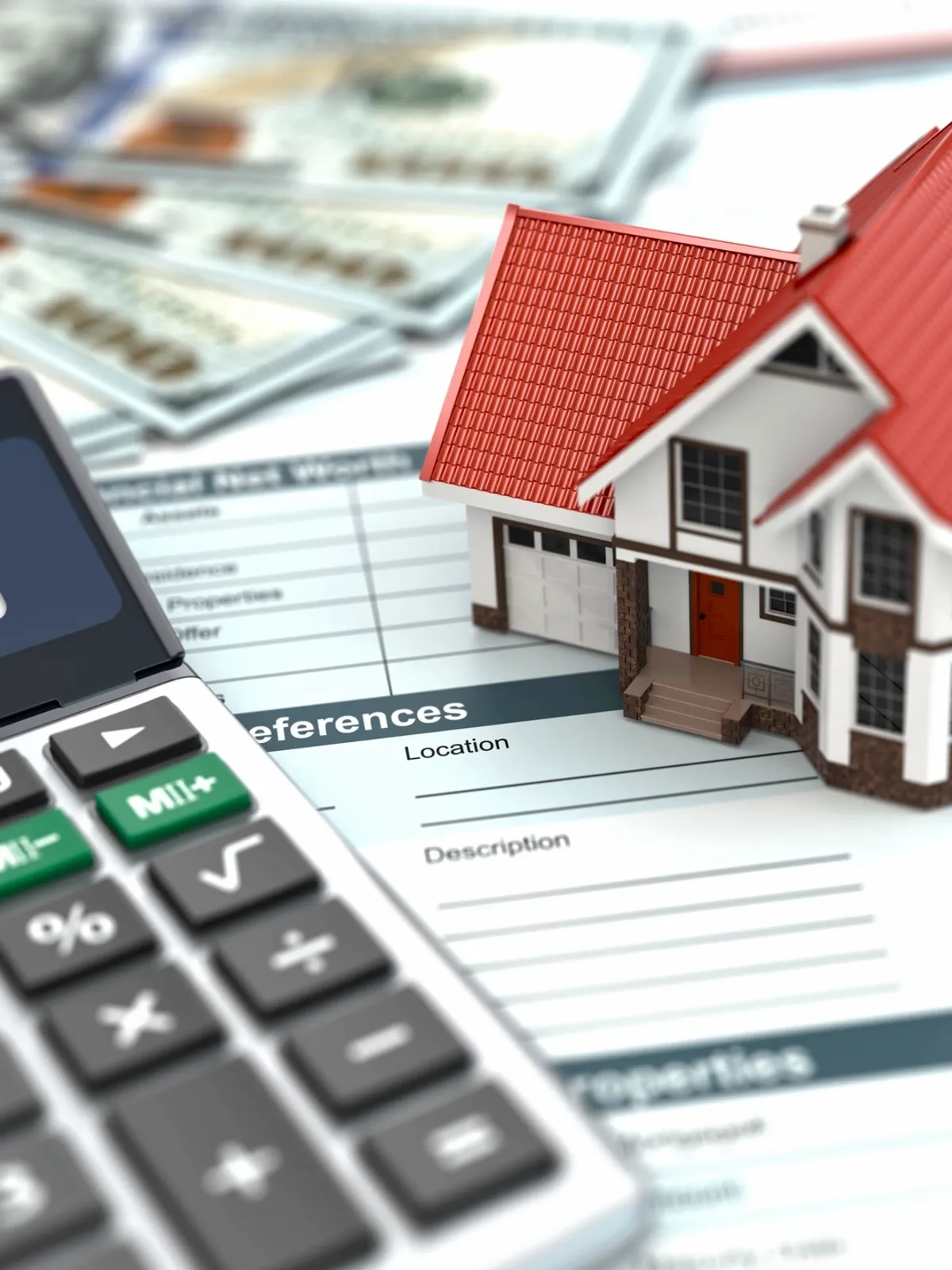 Calculator and house model on financial documents.