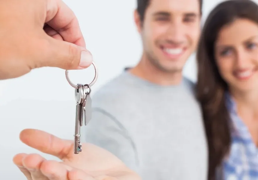 Couple receiving house keys, smiling happily.